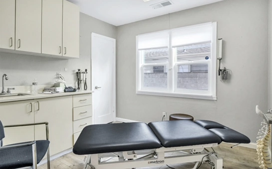 A clean medical therapy room with a padded examination table