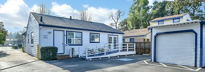 A small white one‑story building with blue trim