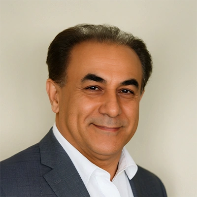 Dr. Majid Rezaei wearing a dark suit jacket over a white collared shirt